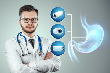 Doctor against the background of a hologram of the stomach, A camera the size of a capsule in the...
