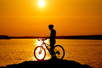 Fototapeta na wymiar Silhouette of the cyclist riding on a sports bike at sunset. Active lifestyle concept.