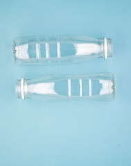 Two empty plastic bottles on a blue background. The concept of encouraging people not to use plastic items to prevent environmental pollution, ecology. The rejection of the plastic