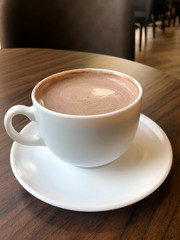 Hot cappuccino coffee cup on black wooden table background. Coffee concept  
