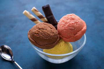 Berry, banana and chocolate ice cream scoops in glass bowl. Cold refreshing summer sweets, restaurant menu or food background