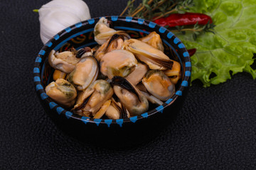 Pickled mussels in the bowl served pepper, garlic and salad