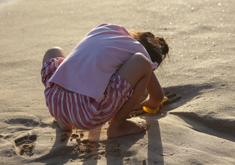 A girl plays in the sand.