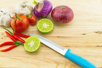 assorted spices for hot and sour soup (Tom Yam) lemon ,red chilli ,onion , garlic and tomato on wooden block