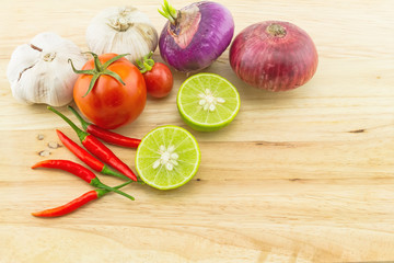 assorted spices for hot and sour soup (Tom Yam) lemon ,red chilli ,onion , garlic and tomato on wooden block