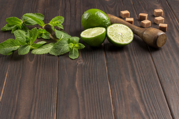 Mint leaves, lime slices. Brown sugar on table.