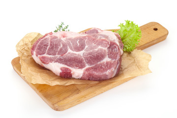 Raw pork steak over wooden board