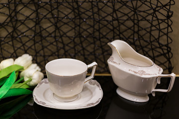 selective focus of Elegant white porcelain dinner set on a black glass table.