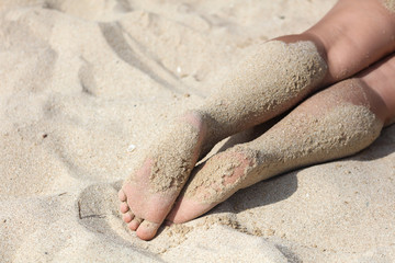 Close-up of a girl's leg on the beach.