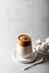 coffee dalgona in a glass on a light background, place for text