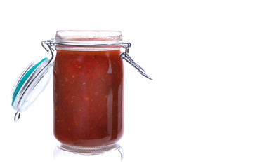 homemade sauce in a glass jar on a white insulated background
