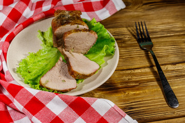 Tasty baked pork with spices on a wooden table