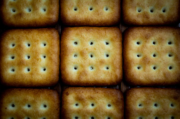 Top view of crispy square shaped biscuits. Salt and sweet biscuits.