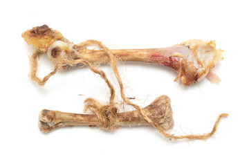 A chicken bone weighs on a rope on a white background.