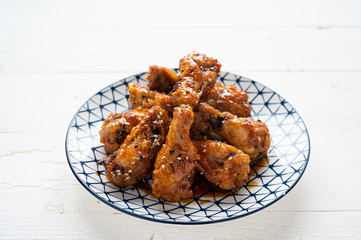 Sour-sweet baked chicken wings sesame and  teriyaki sauce.