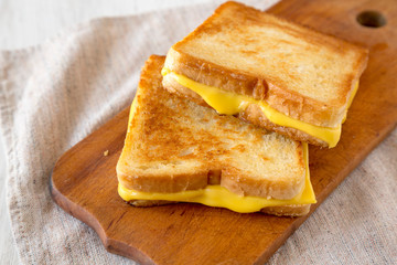 Homemade Grilled Cheese Sandwich on a rustic wooden board, low angle view. Close-up.