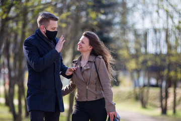 Masked couple walking in the park