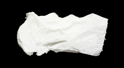 White crumpled napkin, toilet paper on a black background.