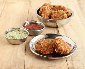 Sabudana vada, made from sago, is a traditional, popular, delicious, and vegetarian snack, native to Maharashtra, India, with coconut chutney and ketchup as side dishes.