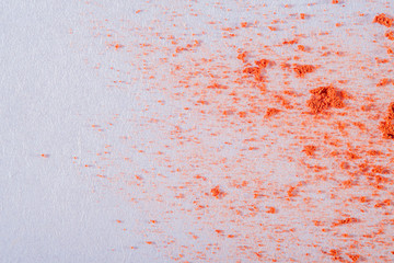 Fototapeta premium Background with sprinkled paprika at high magnification and an empty white background with a place for inscriptions