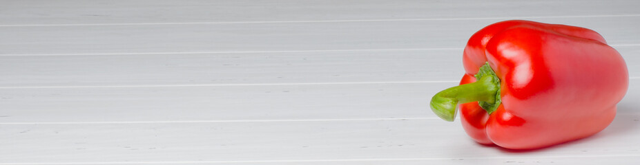 Red pepper on a white wooden background. Copy space