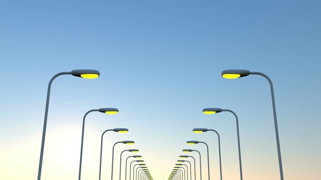 Two rows of lamp posts extinguish lights against the background of dawn. The camera quickly passes under the lights. Seamless loop.