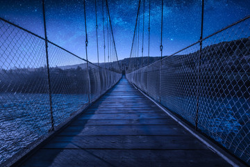 Suspension bridge over the river at night