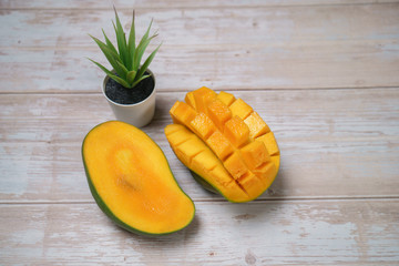 Close up of famous sweet mango in North Malaysia called Harum Manis isolated on top of wooden background. Sweet and juicy. Malaysian and Asian favourite mango.