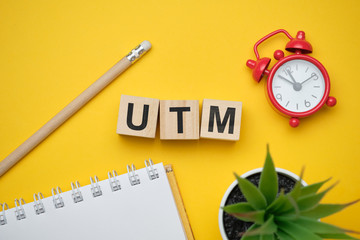 Modern marketing buzzword UTM - Urchin tracking module. Top view on wooden table with blocks. Top...