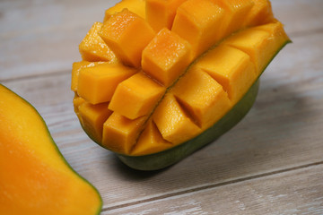 Close up of famous sweet mango in North Malaysia called Harum Manis isolated on top of wooden background. Sweet and juicy. Malaysian and Asian favourite mango.