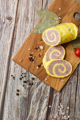 Rolled Stuffed Chicken Breast. Chicken or Turkey Roulade. Low Carb Chicken Roll Ups with cheese on a wooden table with addition of fresh herbs and aromatic spices. Natural product from organic farm.