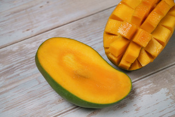 Close up of famous sweet mango in North Malaysia called Harum Manis isolated on top of wooden background. Sweet and juicy. Malaysian and Asian favourite mango.