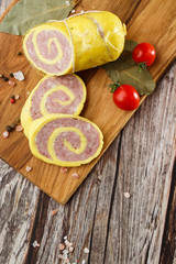 Rolled Stuffed Chicken Breast. Chicken or Turkey Roulade. Low Carb Chicken Roll Ups with cheese on a wooden table with addition of fresh herbs and aromatic spices. Natural product from organic farm.