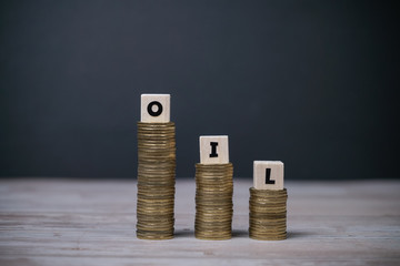 Oil word on step stack coins as graph down. Bear market in crude oil commodity market investment and petroleum industry. Oil prices fall due to covid 19 crisis.