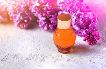 Obraz na płótnie Canvas Honey for spa treatment background with bottle of honey and blooming lilac branches on the table