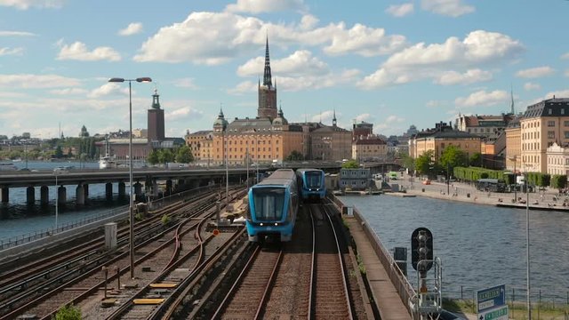 Stockholm City Hall on the left. Two subway trains traveling side by side at the camera. Shooting from a high angle.