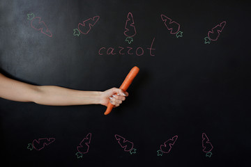 Carrot in the hand. Frame of painted carrots