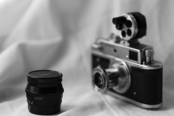 USSR retro lens and blurry photo of a retro camera with an external drum range finder. Space for...