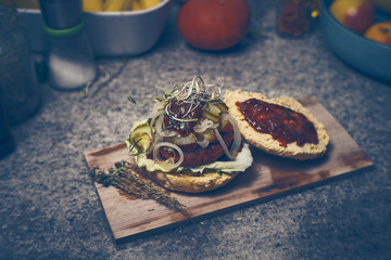 Home made delicious vegan burger with BBQ source and oniens on wood plate