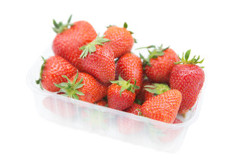 Plastic container with ripe fresh organic strawberries isolated on a white background