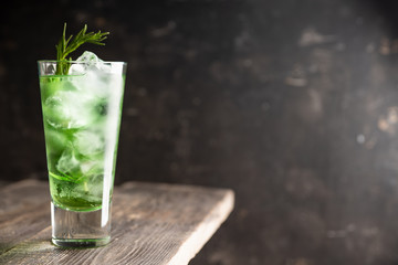 Sweet tequila based green cocktail with tarragon and rosemary. Selective focus. Shallow depth of field.