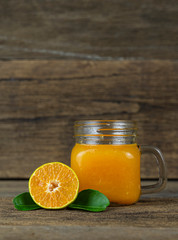 Orange cut in half  and a glass of orange juice on wooden table background.