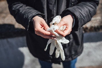 Women putting on plastic medical gloves for protection ageinst Coronavirus