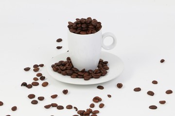 small espresso cup full of roasted coffee beans in the studio
