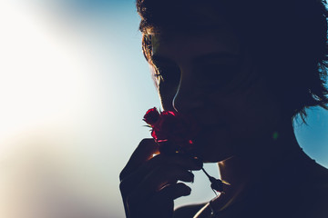 Silhouette of girl isolated on bright light background. Mysterious profile of woman with flower. Concept of intuition, spirituality or sex. Copy space - obrazy, fototapety, plakaty