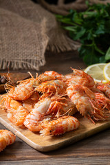 Shrimp on a wooden Board on a brown wooden table. Greenlandic prawns