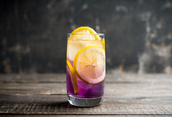 Gin based colorful cocktail with lemon and lavender liqueur on the rustic background. Selective...