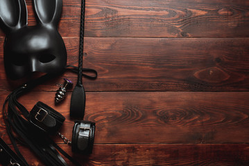Set of erotic toys for BDSM sex. Lash, handcuffs, leather belt, mask and a plug