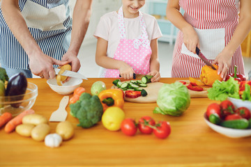 Family cooks fresh vegetables on the table in the kitchen.