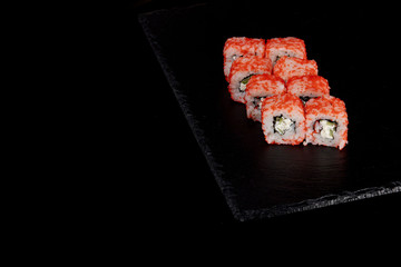 Philadelphia roll with salmon, cheese and cucumber on a black background. Sushi Philadelphia